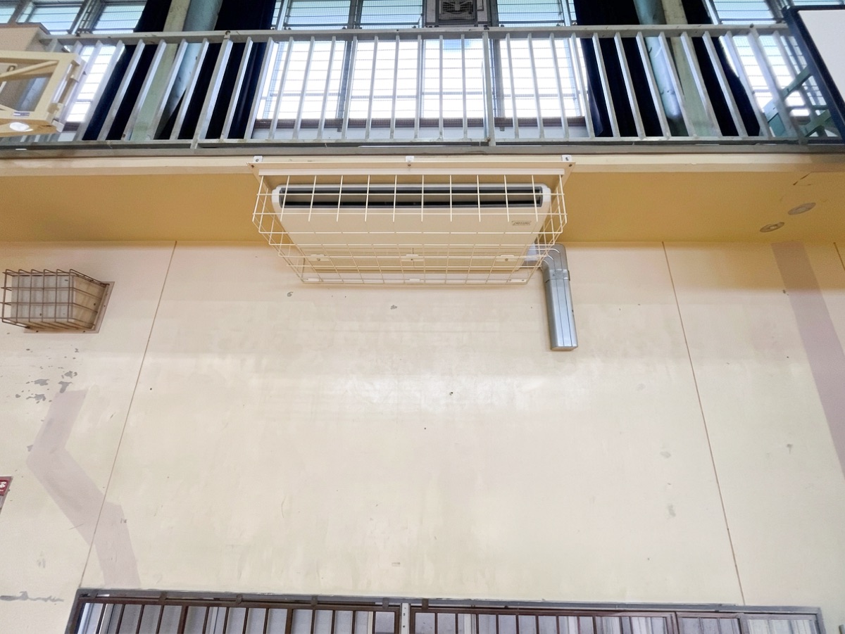 体育館の壁面に設置した保護ガード付きの室内機